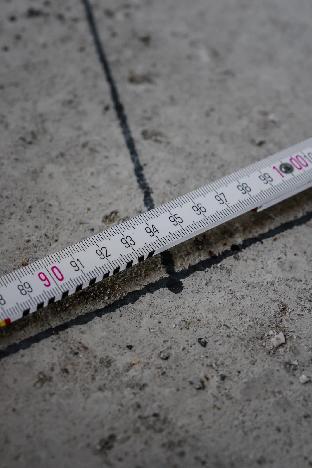 Kontrolle einer Bodenmarkierung mit dem Maßstab